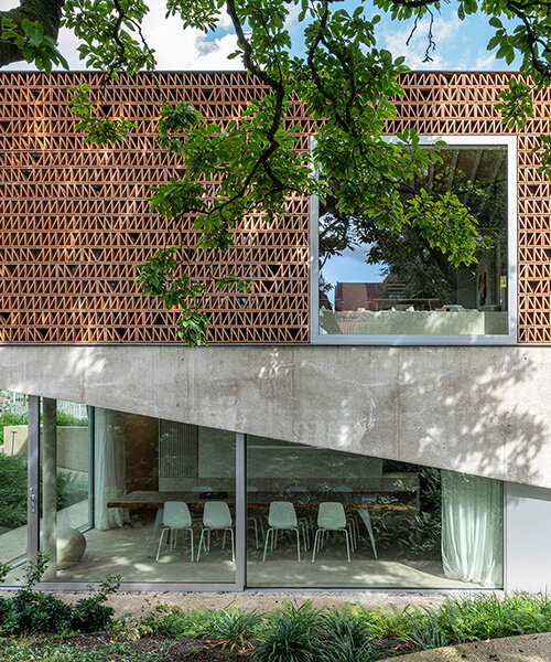 Téglás rácsos homlokzat szűri a napfényt a belga irodában