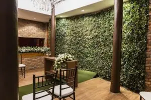 Charming indoor venue with brick walls, floral arrangements, and greenery suitable for events.