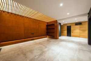 Modern corridor interior with entrance door and air conditioning against wooden shelves above floor in house