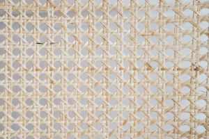 Close-up of a woven rattan texture featuring a geometric, hexagonal pattern.