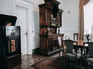 Vintage dining room interior featuring an ornate wood cabinet and gramophone with antique decor.