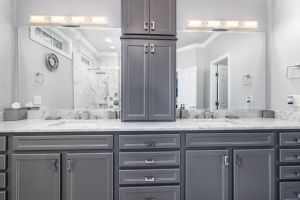 Sleek gray bathroom with dual sinks and marble countertop, showcasing modern design.