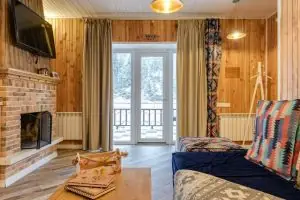 Warm and inviting living room with wooden decor, fireplace, and large windows.