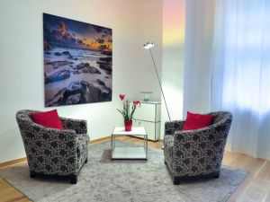 Elegant living room showcasing modern chairs, art, and decor for a stylish home setup.