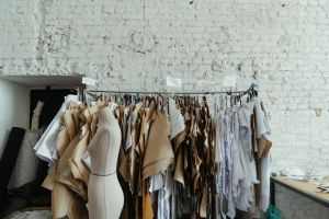 Industrial fashion studio interior with various sewing patterns and mannequins against a brick wall.
