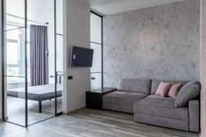 Contemporary living room interior with decorative cushions on couch against television and glass wall at home