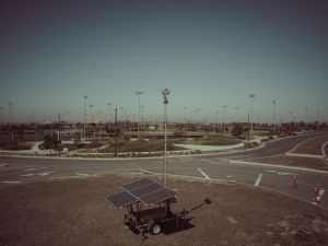 A mobile solar power unit in an open field area captures clean energy.